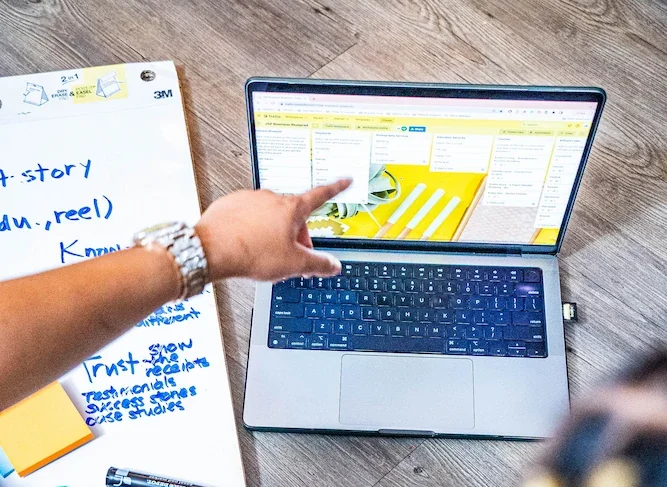 Image of Black hand pointing to computer screen